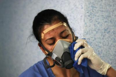 Médico se retira careta de protección durante pandemia por COVID-19