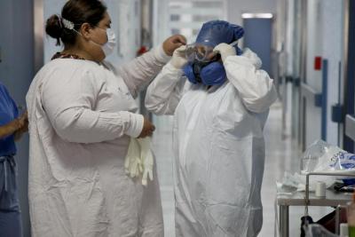 Doctora le coloca a su compañera lentes de protección en área covid 