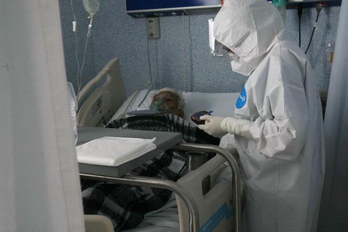 Médico mide glucosa a paciente con COVID-19