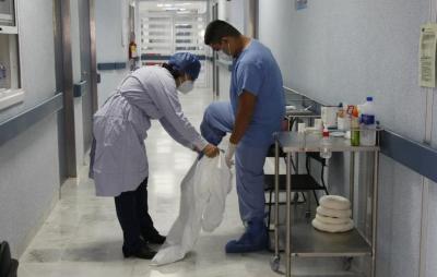 Médico se coloca traje de protección contra COVID-19 con ayuda de otro médico