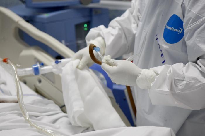 Médico ajusta conexiones de oxígeno a paciente