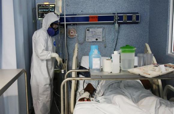 Médico junto a charola con alimento y medicamento para paciente