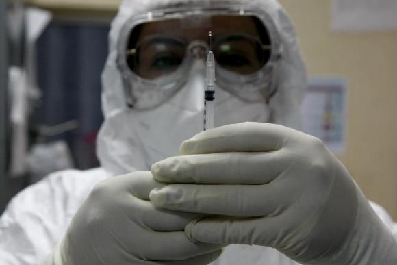 Médico prepara jeringa con medicamento