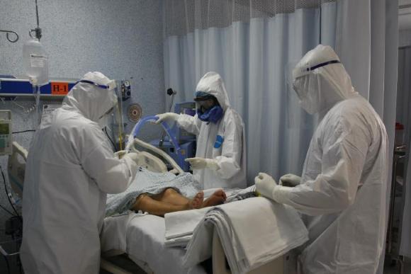 Personal médico realiza el cambio de sábanas a paciente con covid-19