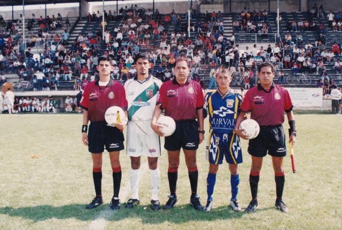 Capitanes de equipos posan con árbitros antes del partido en el Estadio La Martinica 