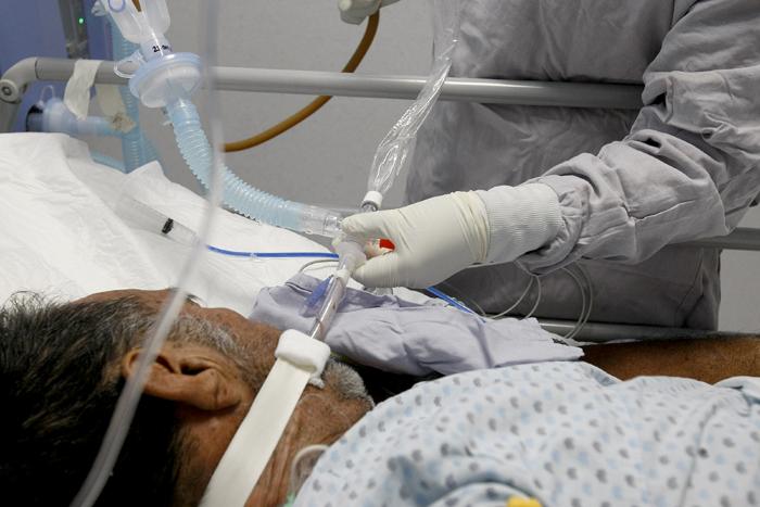 Médico ajusta respirador artificial a paciente