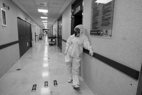 Médico con traje de protección descansa en pasillo del Hospital General de León en vísperas de Nochebuena