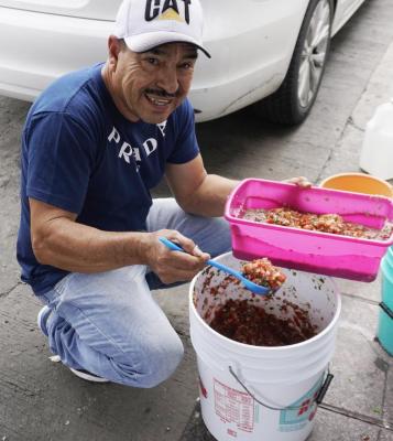 Juanito en su puesto de guacamayas preparando la salsa tradicional 