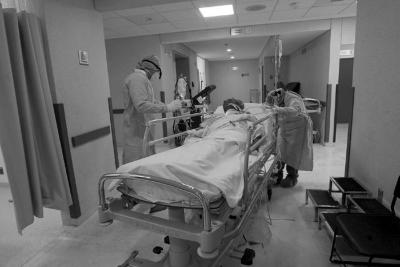 Paciente es trasladado en camilla de hospital por dos médicos 