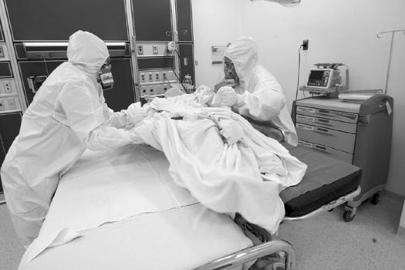 Médicos mueven a paciente covid de una camilla a otra