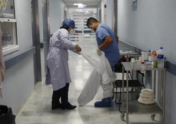 Personal médico se coloca traje de protección en pasillo del Hospital 
