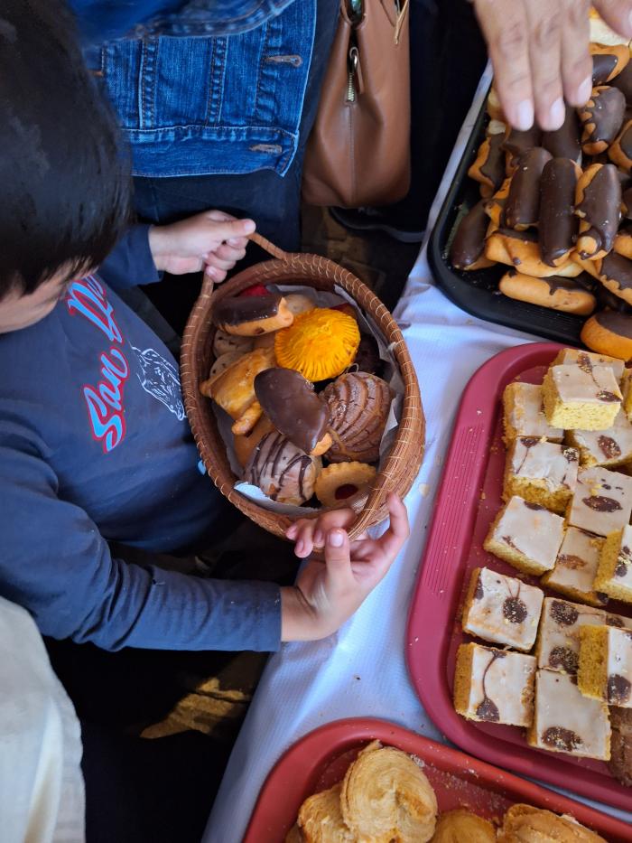 Niño con charola repleta de panecitos 