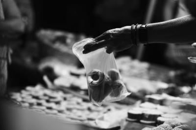 Vendedora hace entrega de bolsa con panecitos