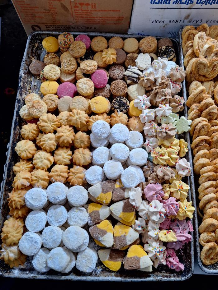 Charola con variedad colorida de panecitos, pastitas y merengues