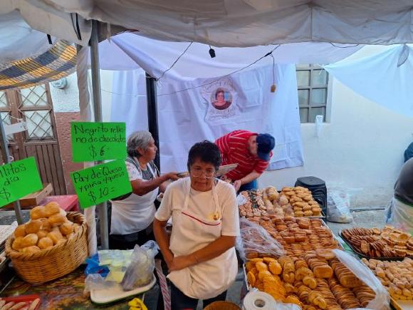 Vendedores de panecitos junto a carteles