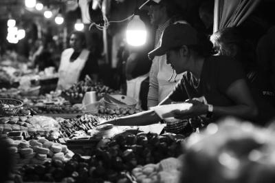 Vendedora de panecitos junto a charolas  