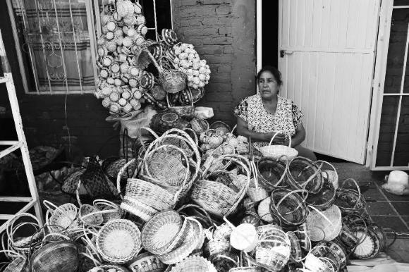 Vendedora de canastas de mimbre espera clientes