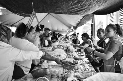 Clientes y vendedores de panecitos en el Barrio Arriba 