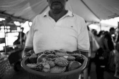 Hombre con cesta llena de panecitos 