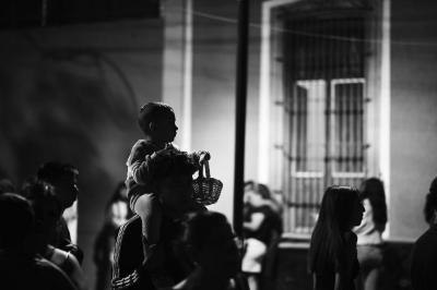 Hombre con niño en hombros camina por la calle Aquiles Serdán