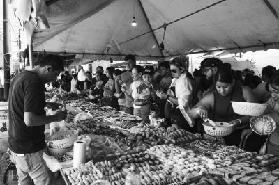 Clientes y vendedores de panecitos en el Barrio Arriba 