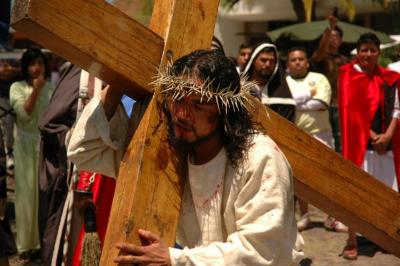 Jesús carga la cruz en viacrucis 