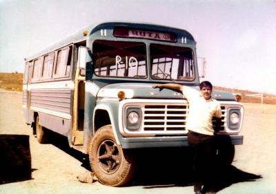 Chófer posa frente a ruta de transporte público (Ca.1970)